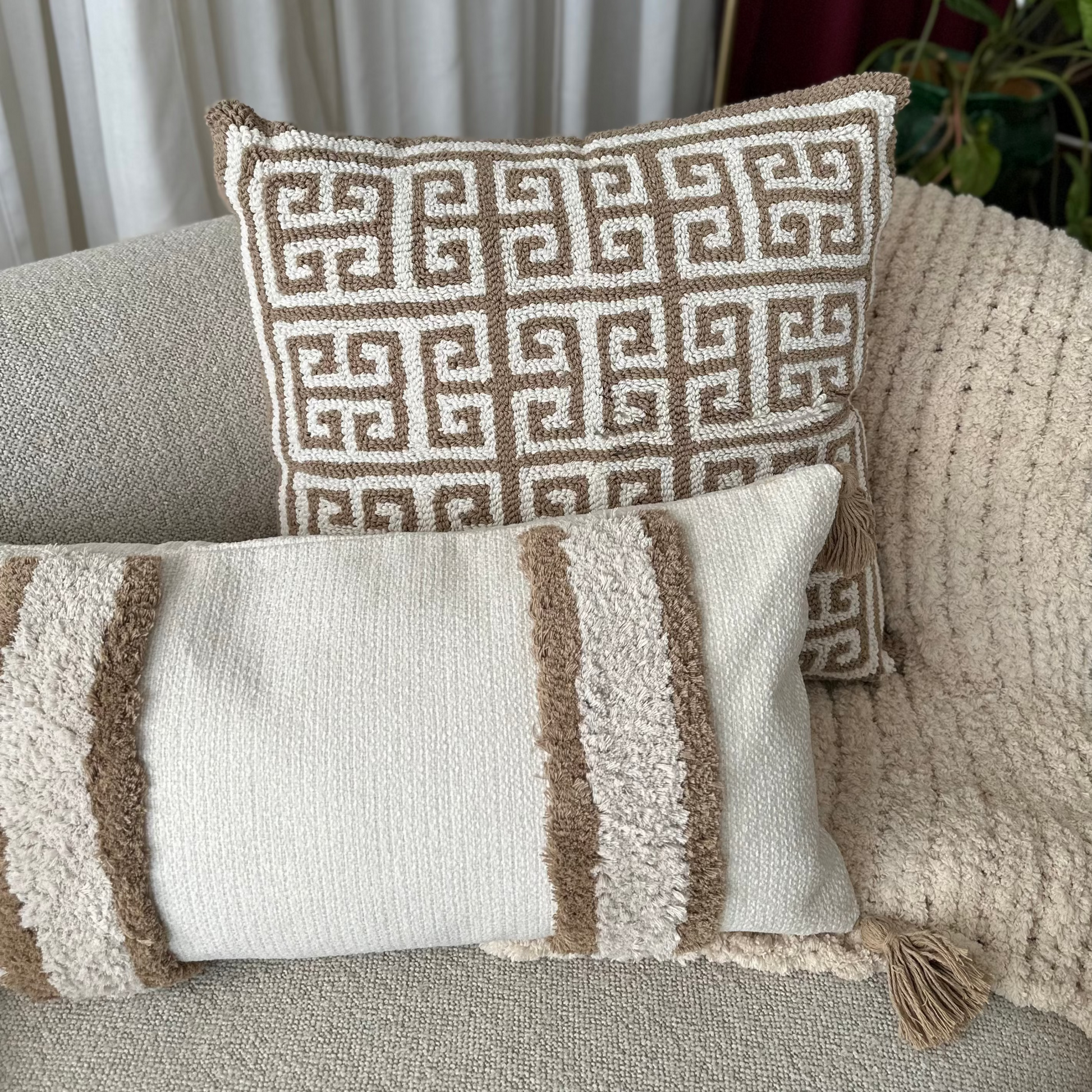 Decorative pillows on a sofa with a geometric pattern and striped design.