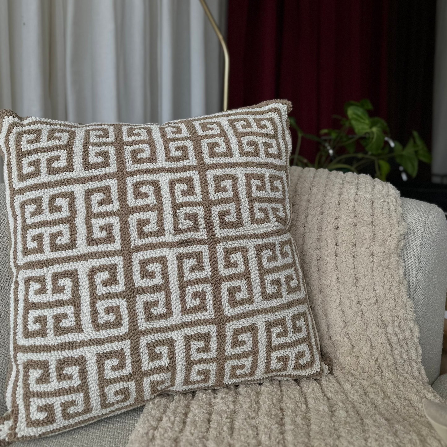 Decorative pillow with geometric pattern on a textured chair