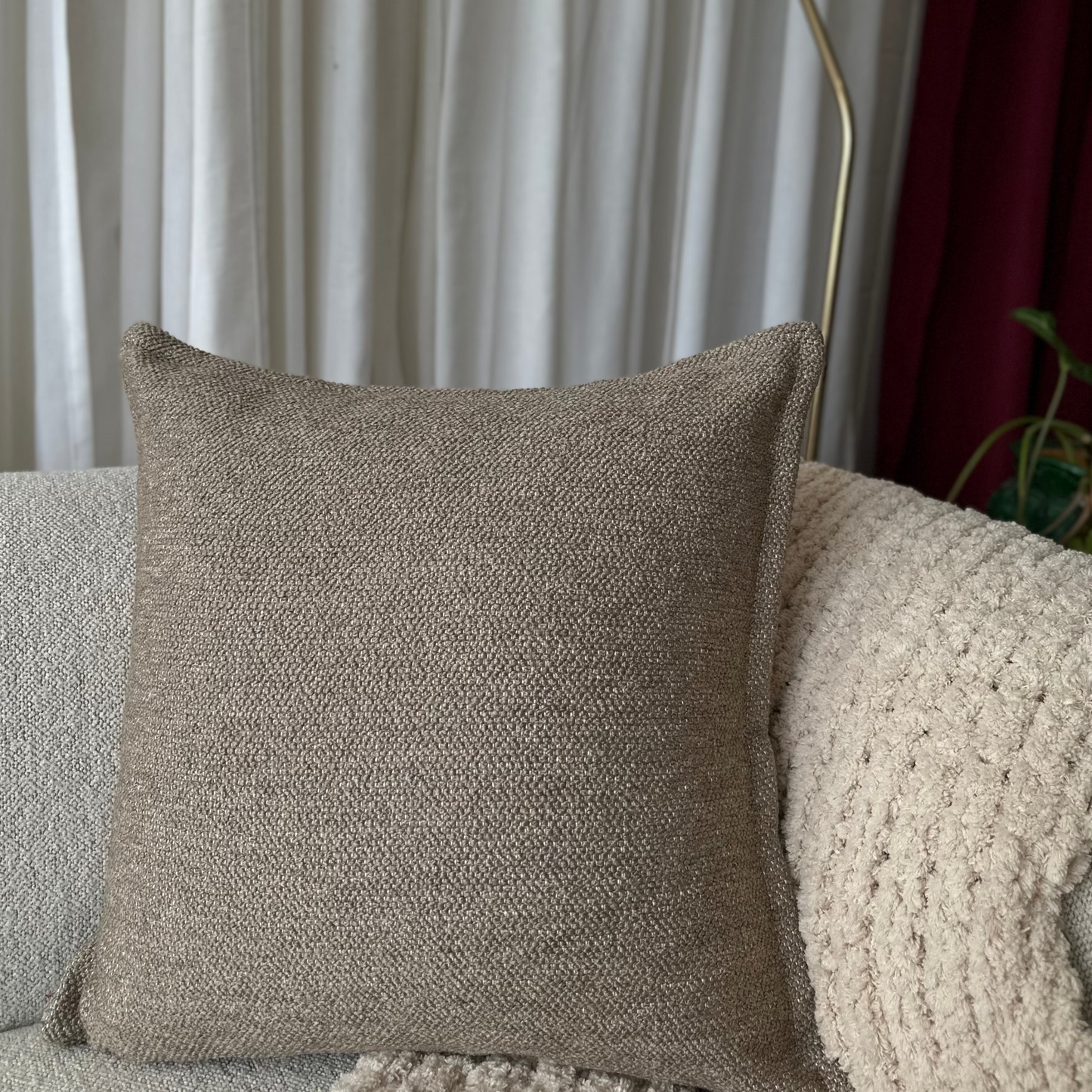 Brown textured pillow on a sofa with a neutral background
